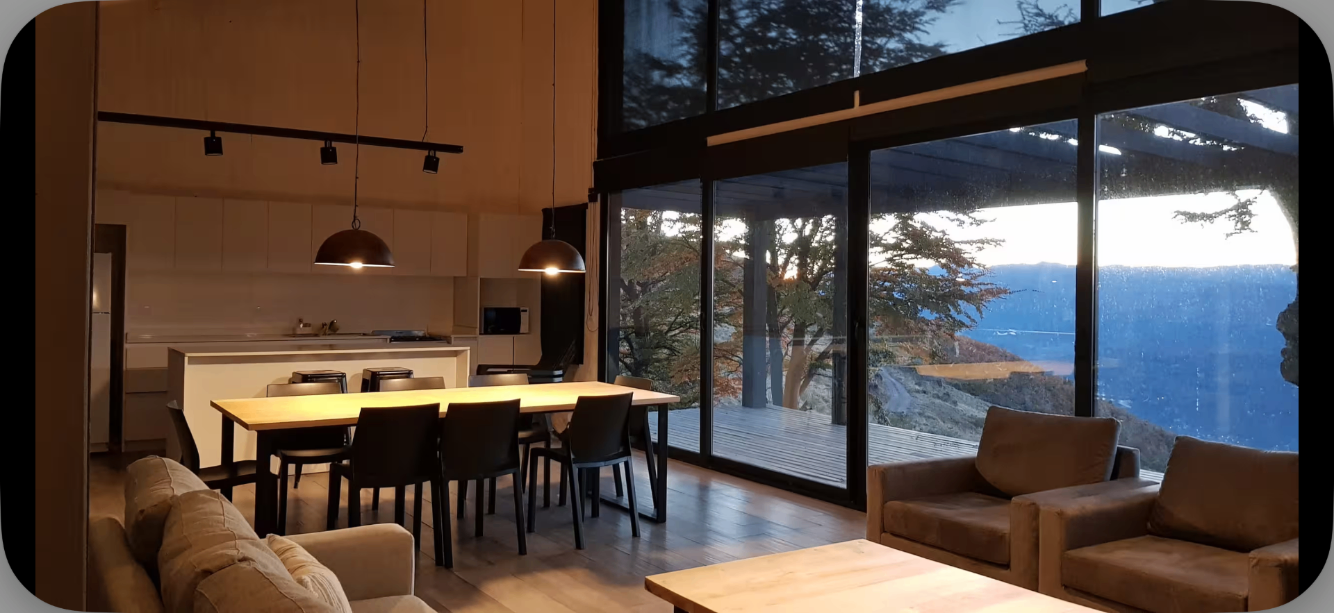Interior do chalé com pé-direito duplo e vista para os Andes